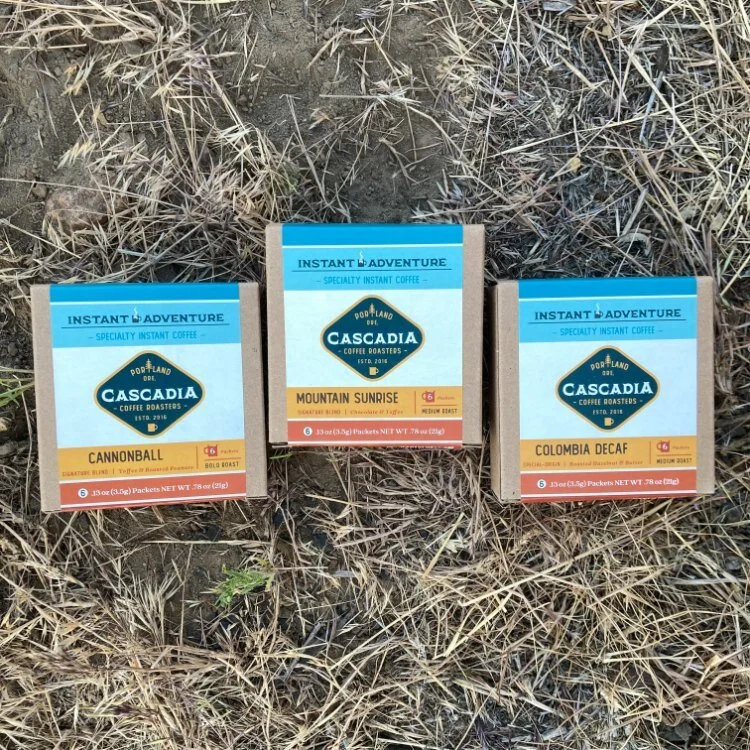 Cascadia Instant coffee being mixed into water at a campsite.