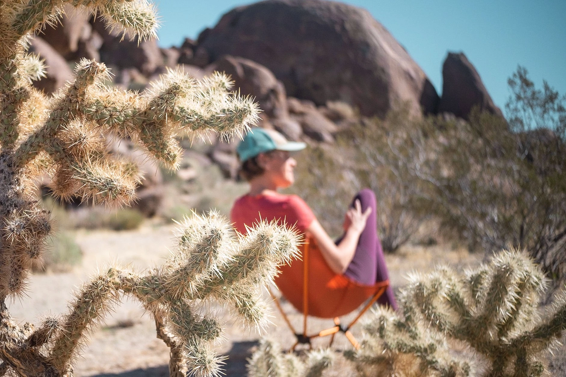 A backpacking chair set up on damp, uneven terrain to avoid ground contact.