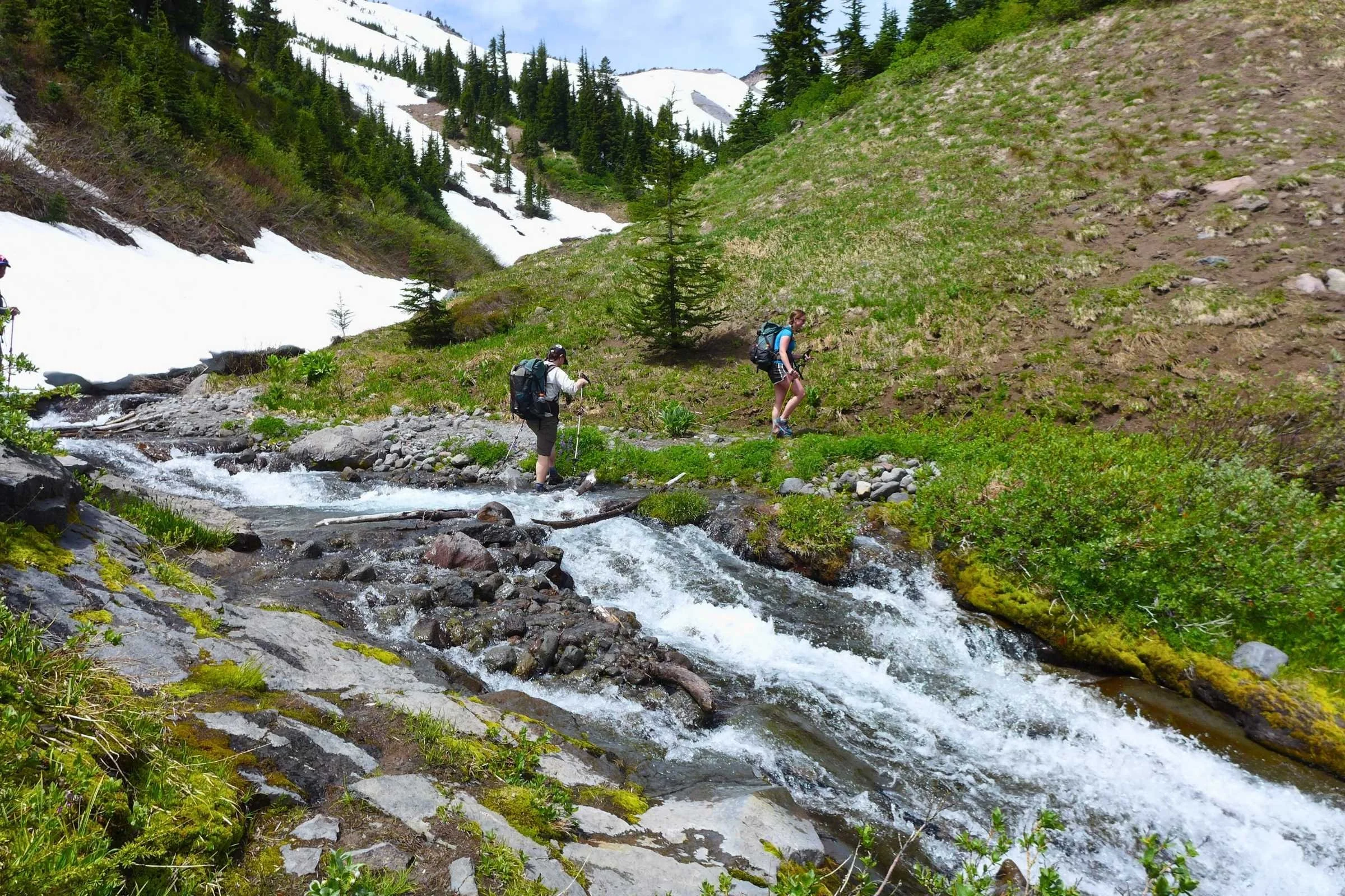 A hiker traversing a rocky volcanic ridge on the north face of Mt. Hood.