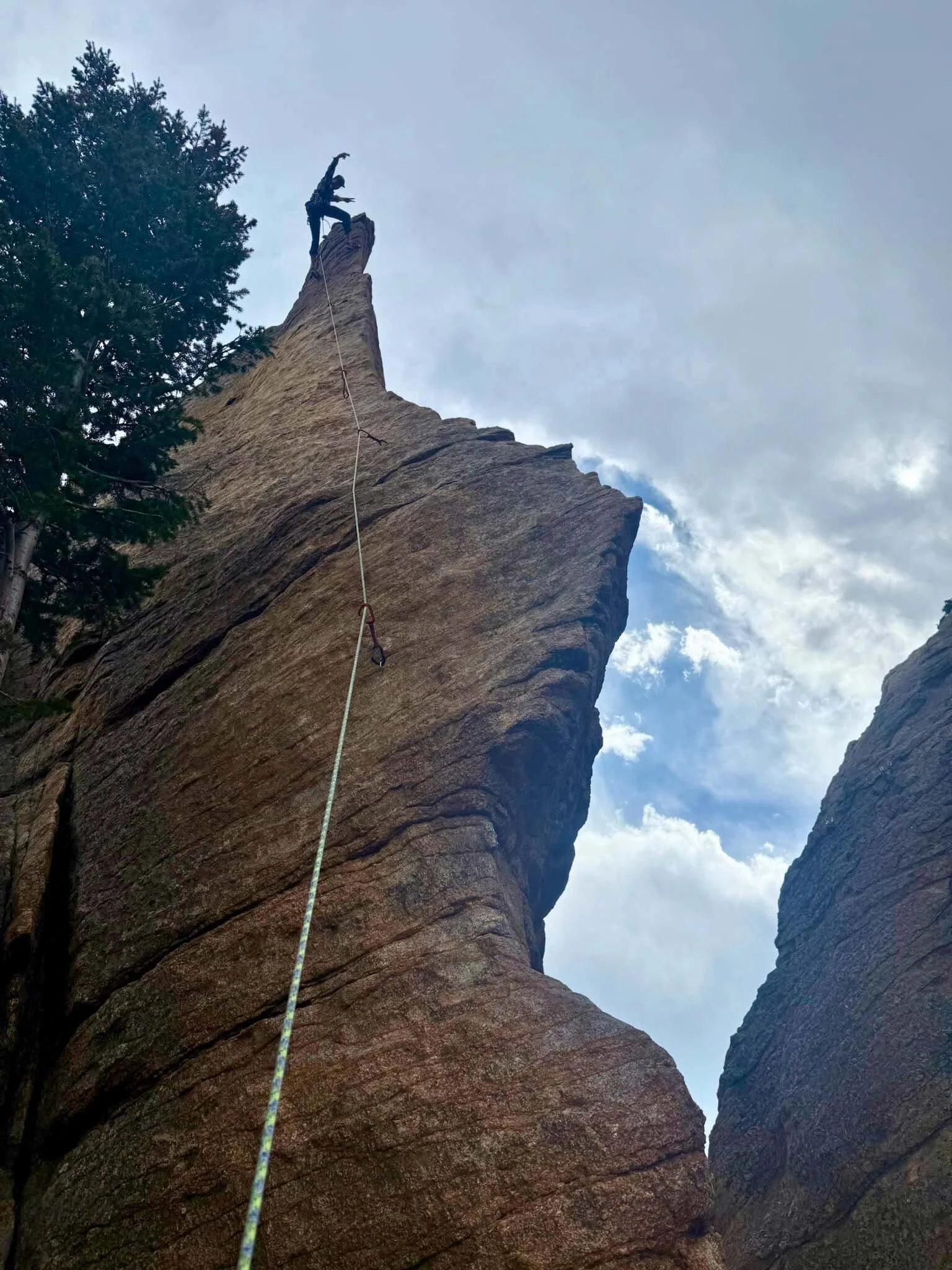 A climber testing gear on a rock face at The Fin in Rocky Mountain National Park.