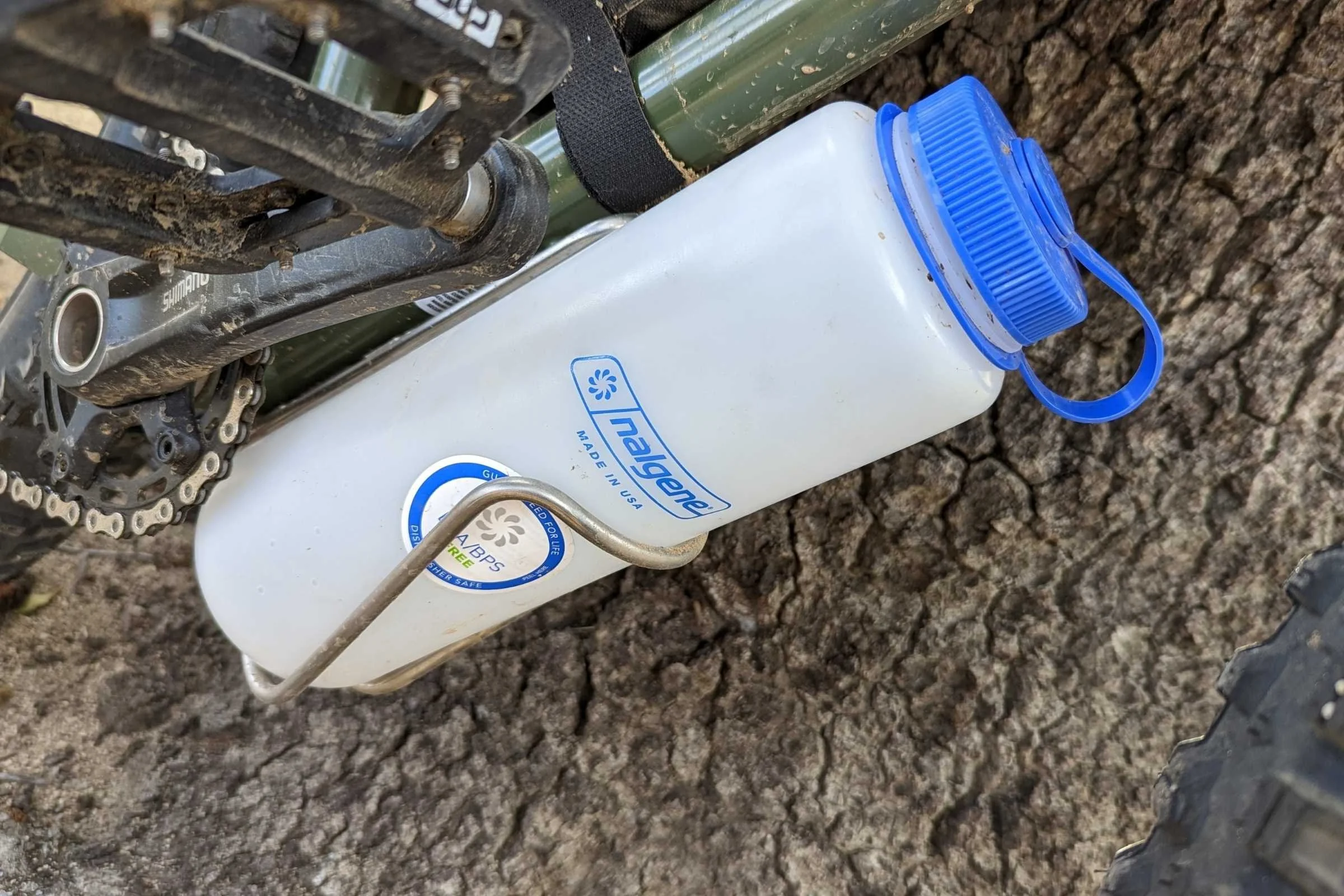 A Widefoot Litercage holding a large 1-liter Nalgene bottle on a bicycle frame.