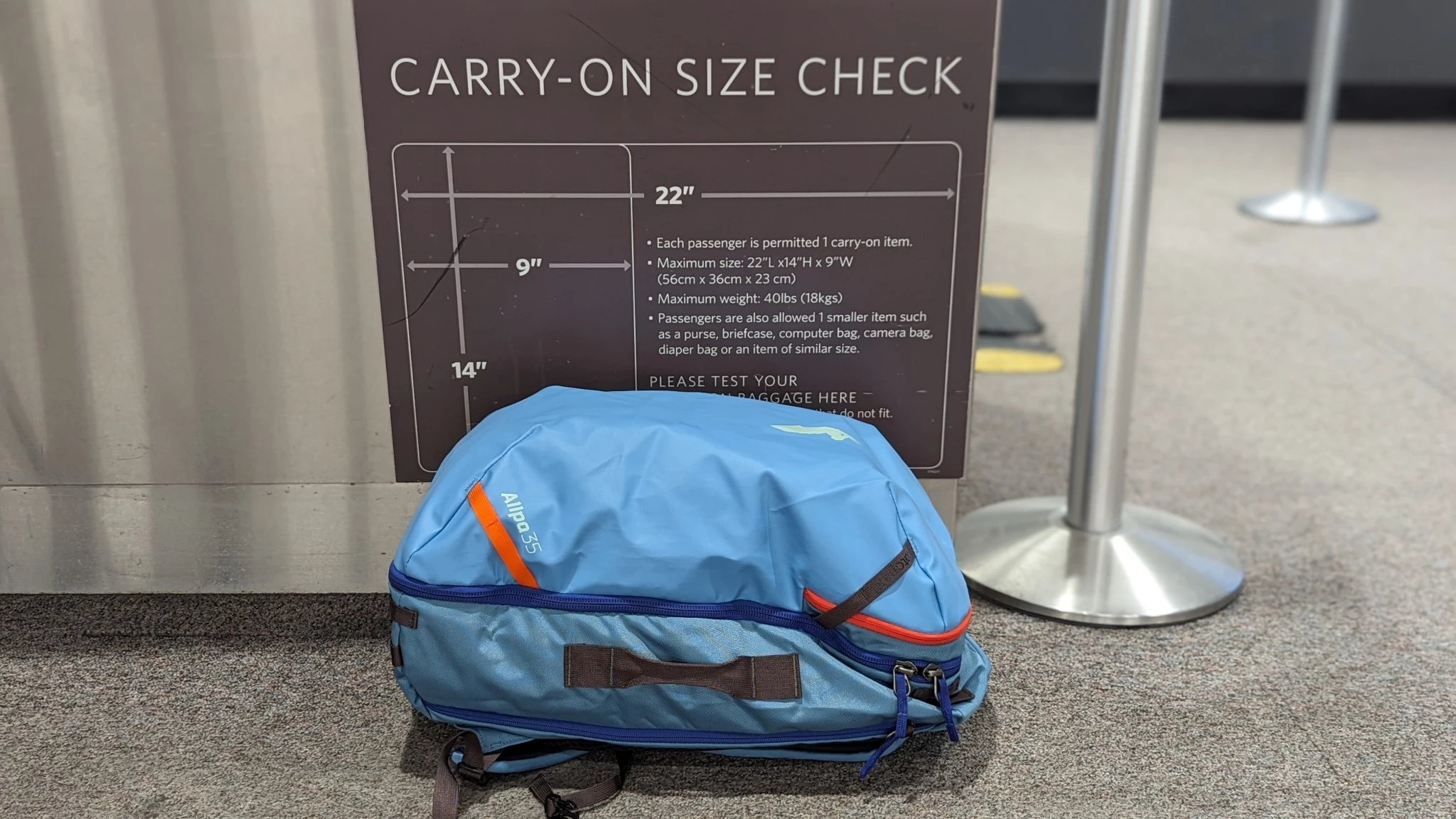 A travel backpack positioned near an airport boarding area.