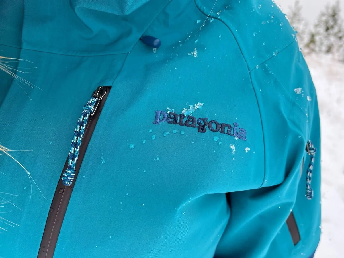 An outdoor enthusiast wearing a high-performance 3-layer Gore-Tex ski jacket in a snowy mountain setting.
