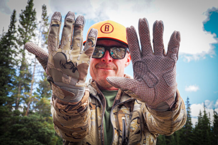 A hunter wearing Kuiu Attack Gloves while at an elk camp site.