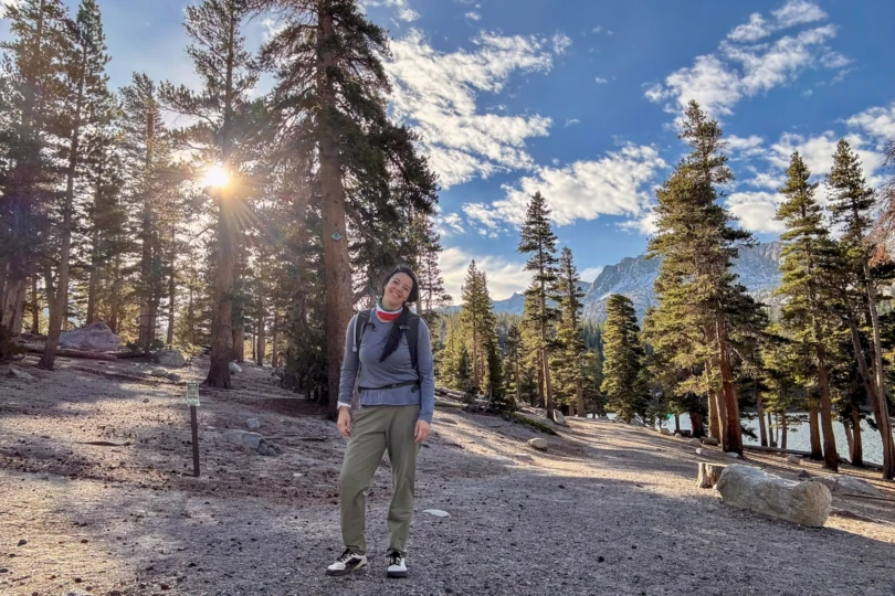 A hiker wearing the Notace Yama T1 navigating a forest trail with visible rocks and roots.