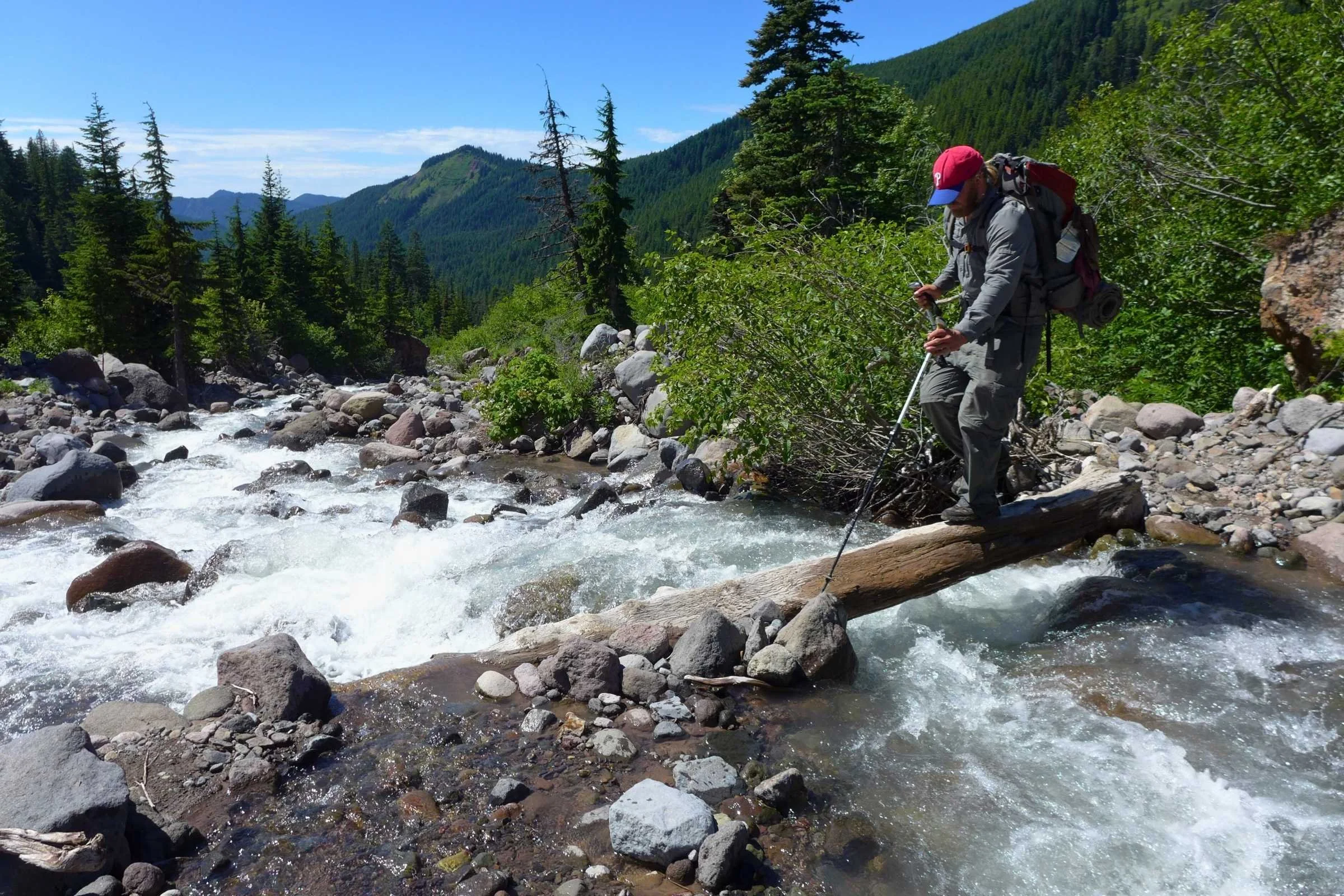A water filter being used in a stream clouded with grey glacial silt.