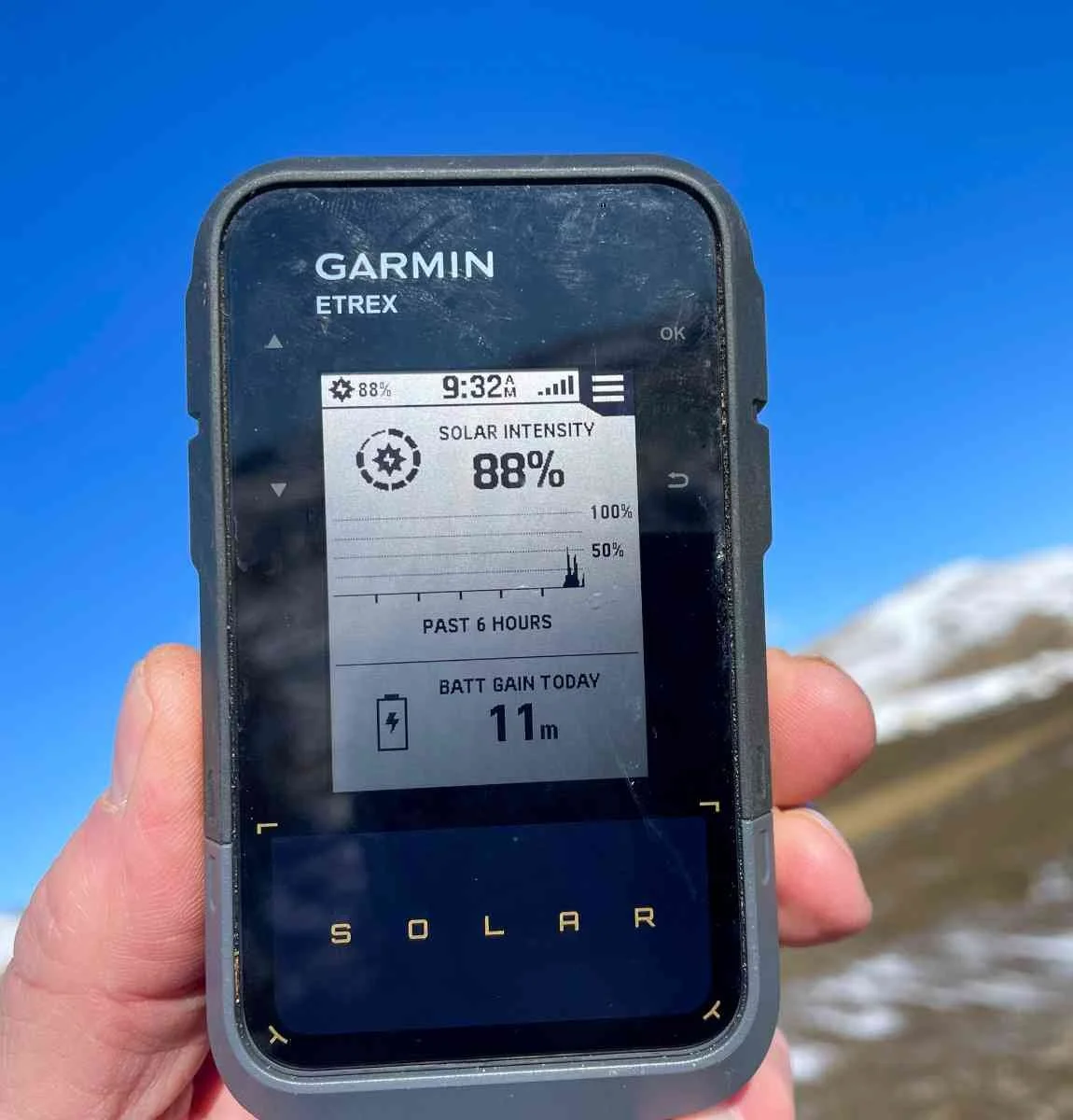 The display of a Garmin eTrex Solar showing real-time solar intensity and battery tracking.