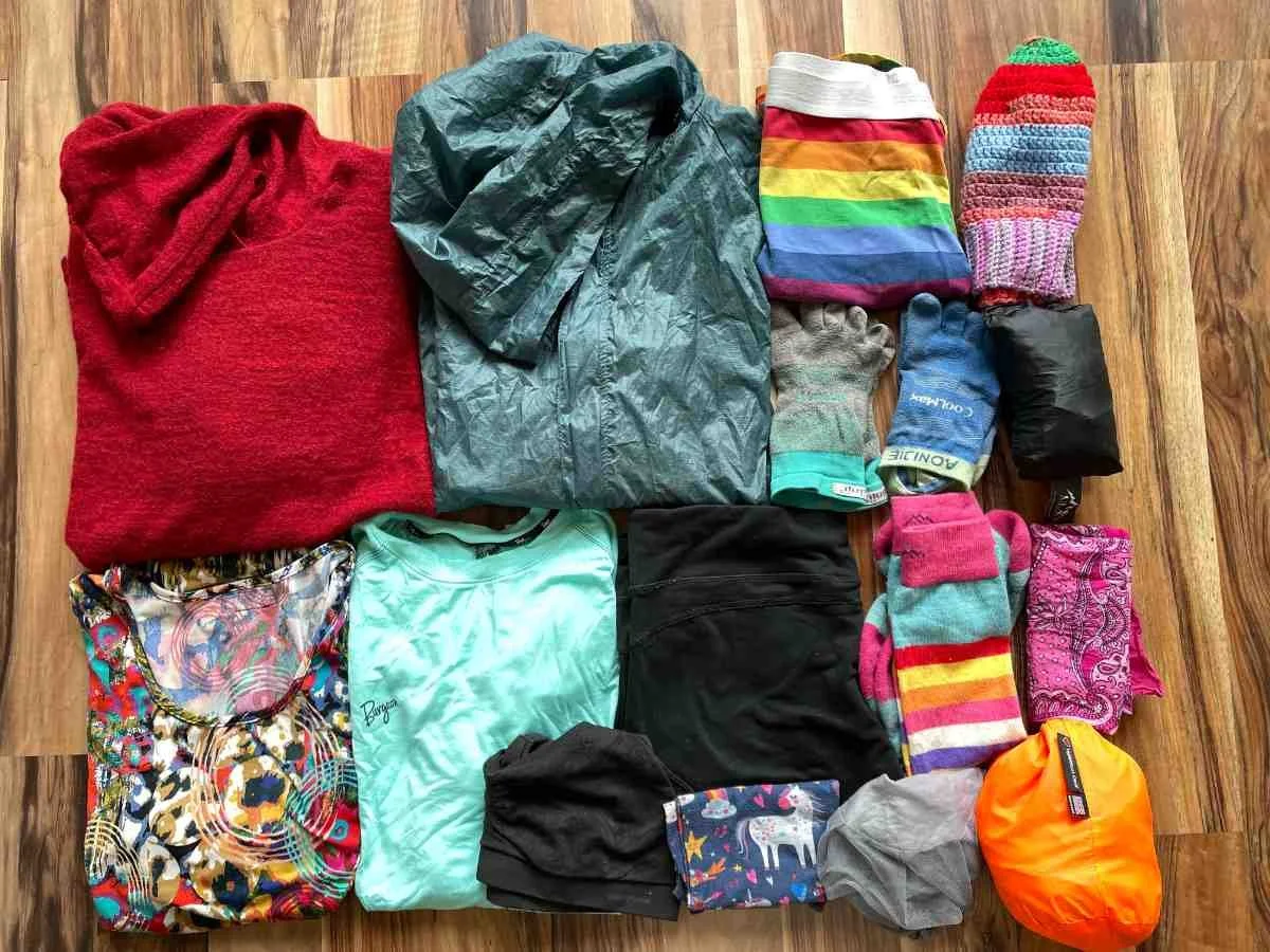 Close-up of lightweight summer hiking layers, including a thin hat and windbreaker.