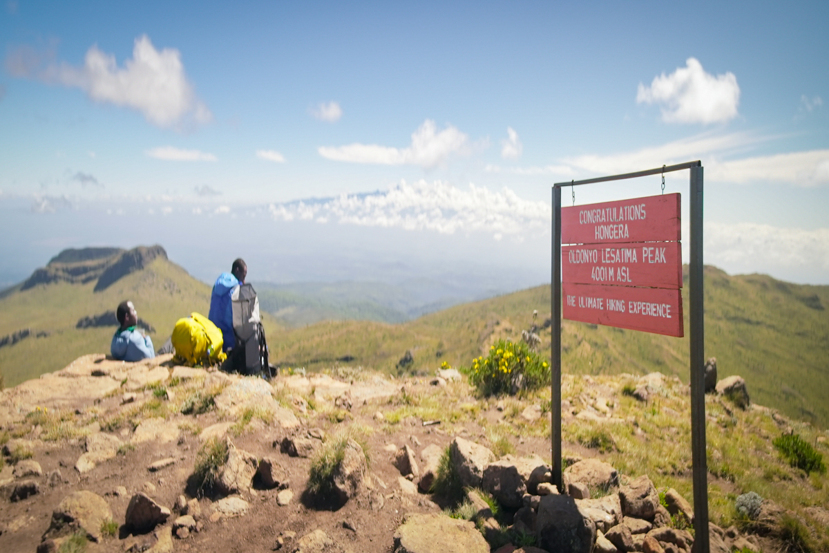 Hikers taking a break on the rocky summit of Mount Satima.
