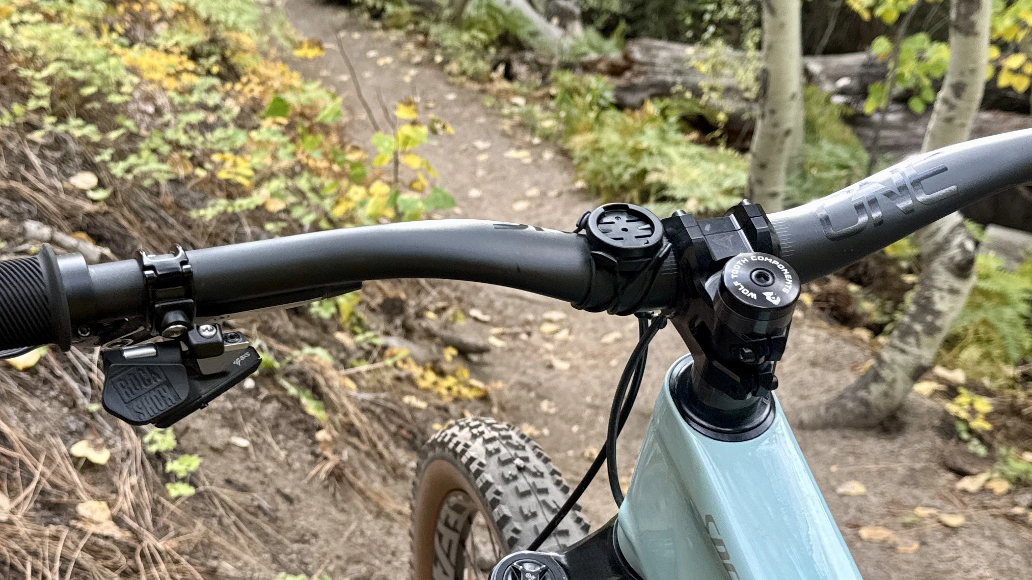 Close-up of a OneUp V2 Carbon handlebar installed on a mountain bike frame.