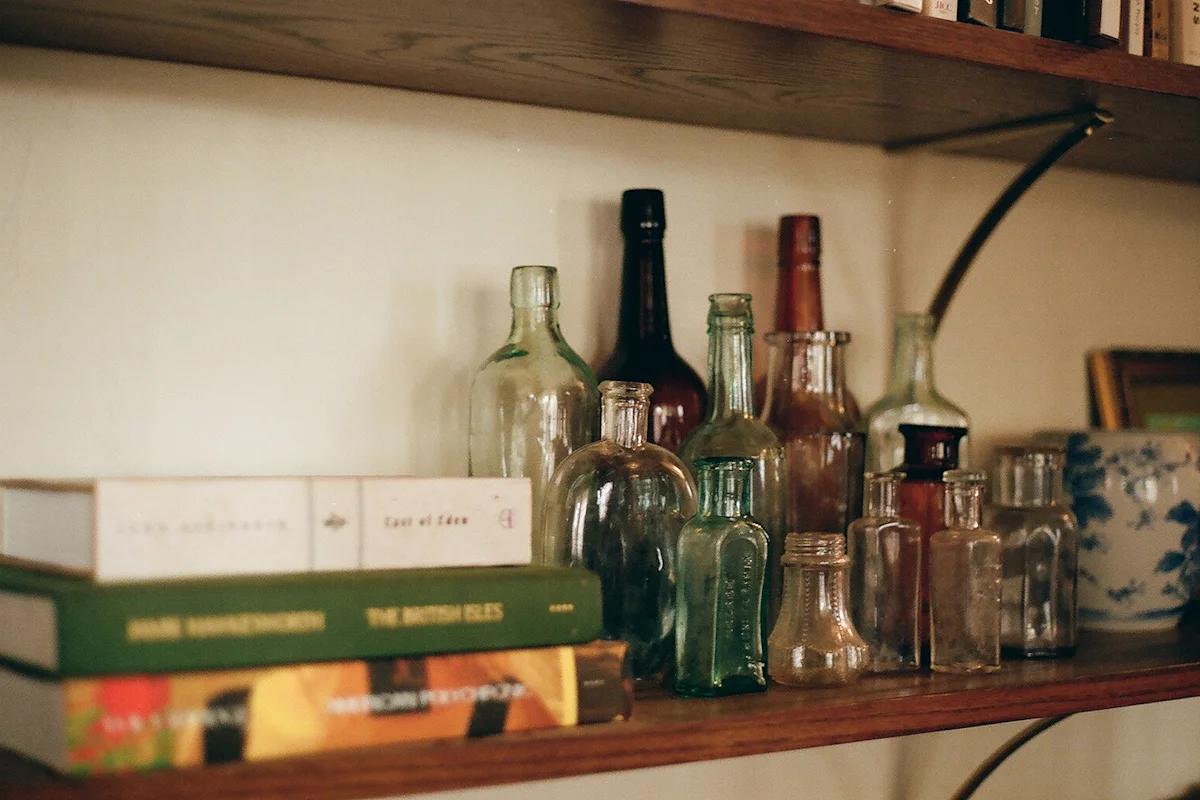A collection of antique glass bottles with distinct colors and shapes displayed together.