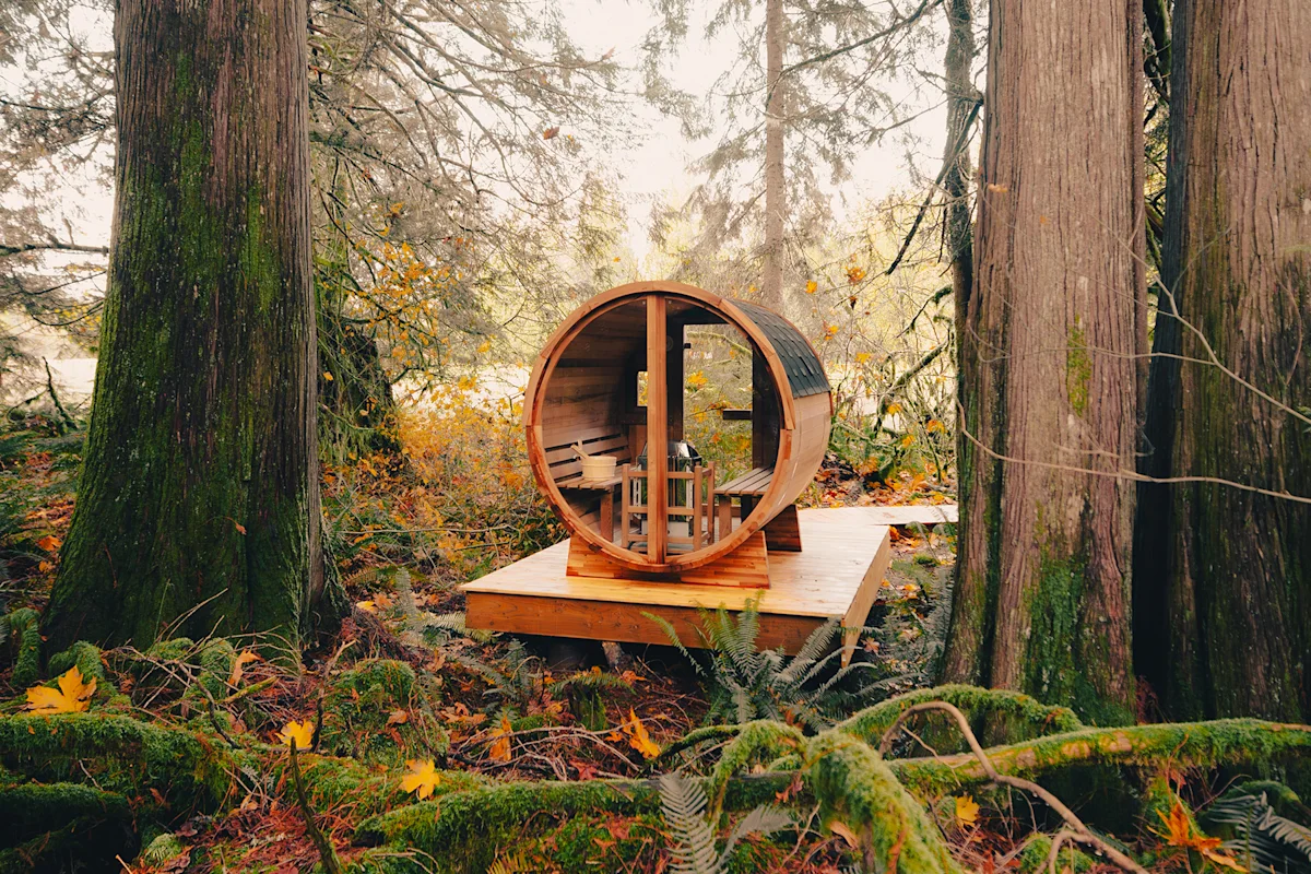 A wooden barrel sauna placed in an outdoor residential setting.
