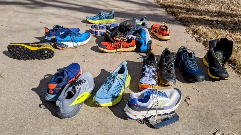 A large collection of various trail running shoe models lined up for testing.
