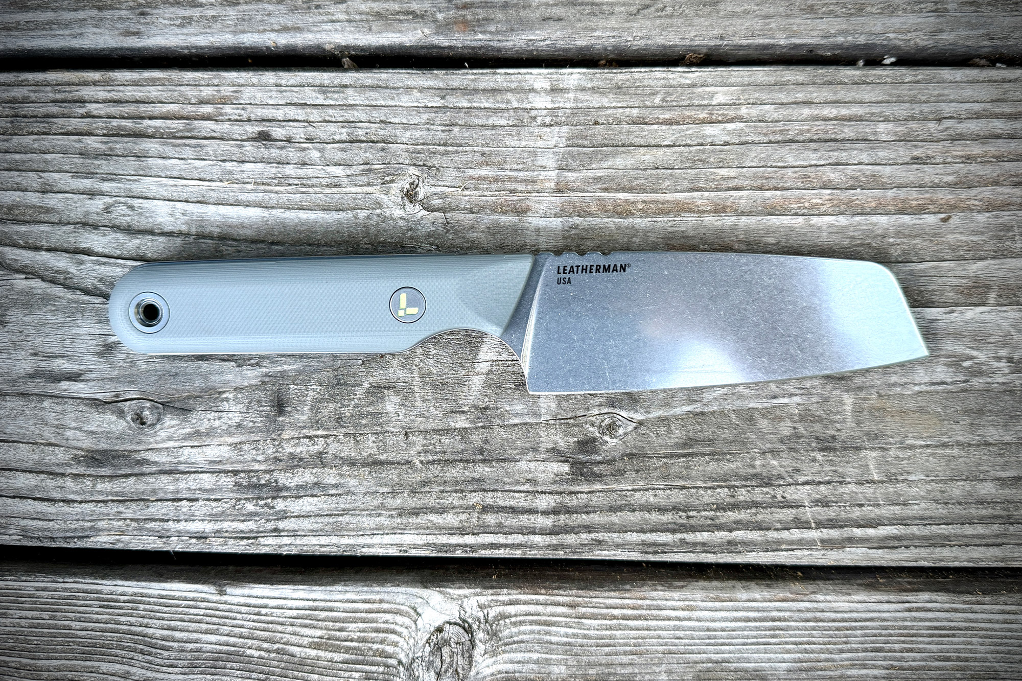 Close-up of the Leatherman Rustle resting on a weathered wooden plank.