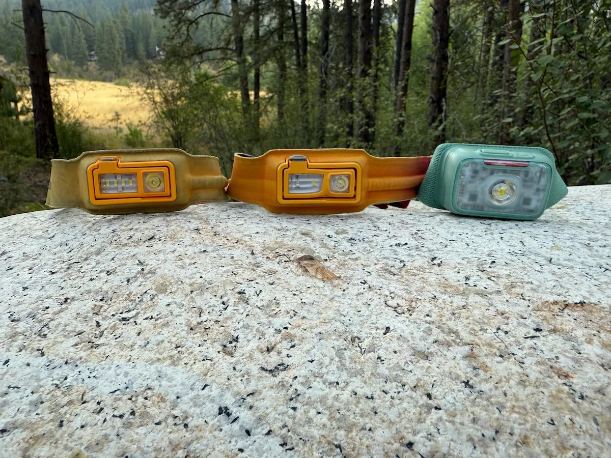 Three generations of BioLite headlamps placed in a row for size and material comparison.
