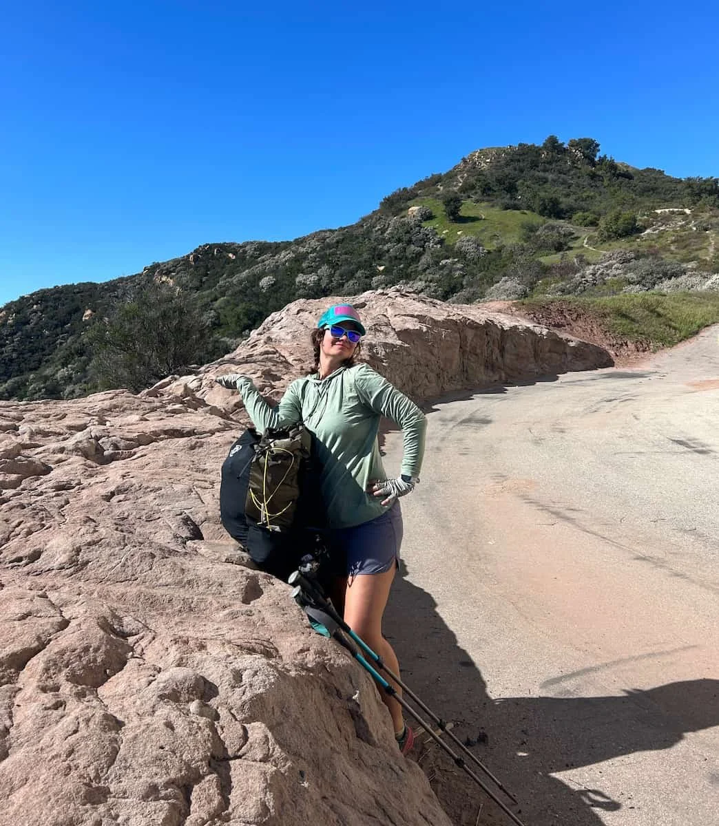 A backpacker with professional gear hiking on a ridge with Saddle Peak in the background.