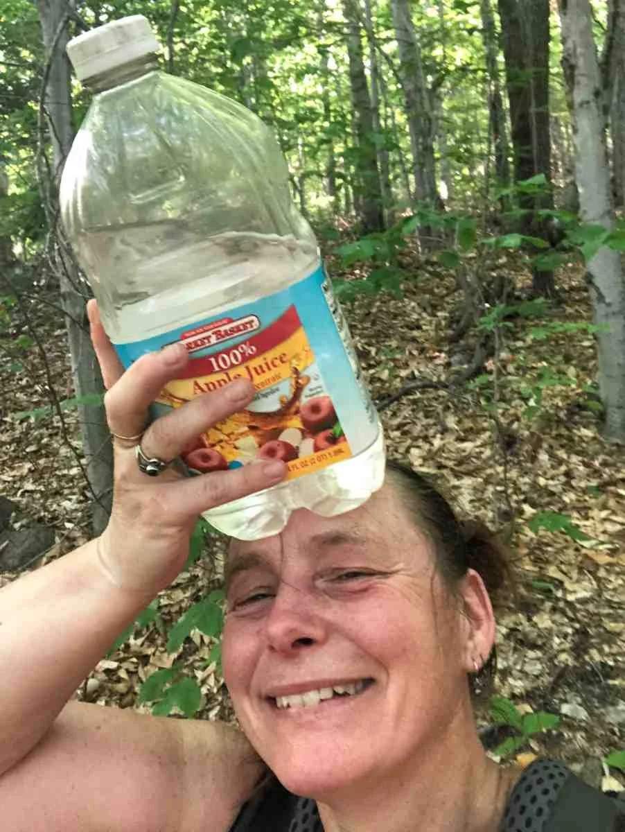 A hiker dousing themselves with water to cool down during a summer trek.