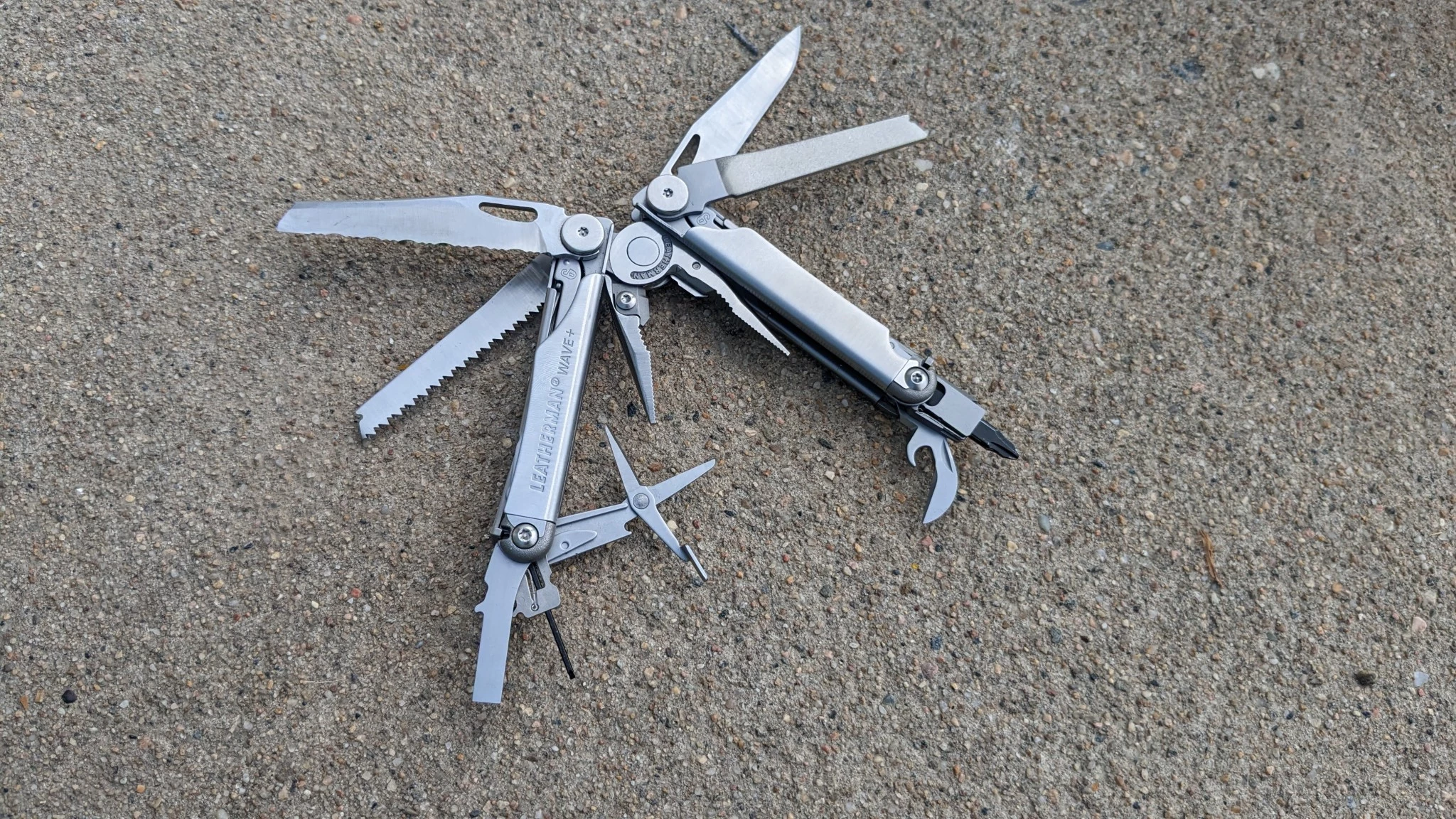 A Leatherman Wave+ multi-tool with all its blades and tools fanned out.
