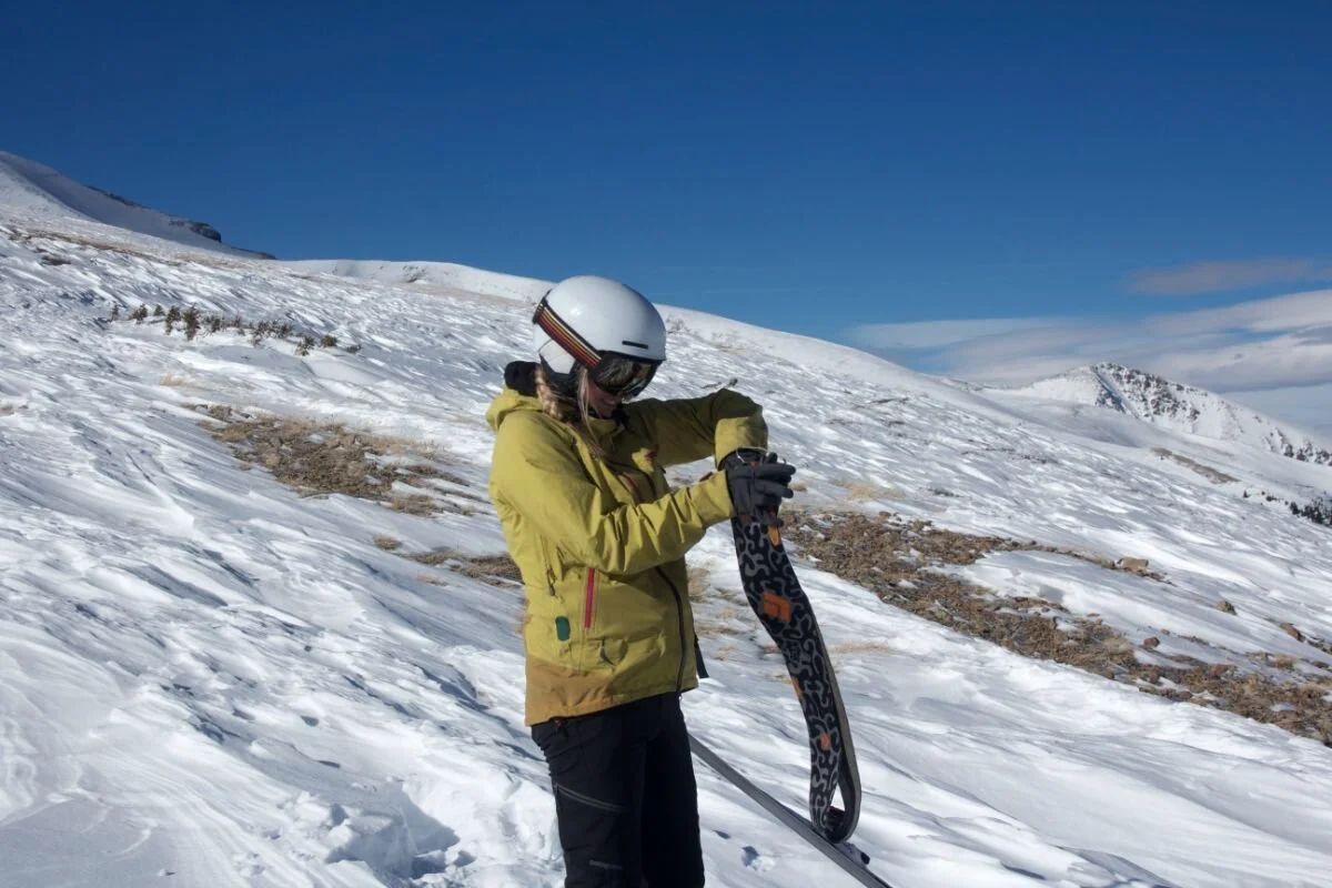 A technical jacket with a visible dark grey patch on the side being worn outdoors.