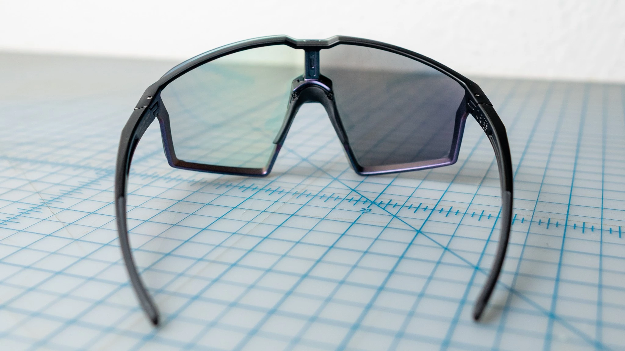 A pair of photochromic cycling sunglasses with one lens darkened and the other clear to show VLT range.