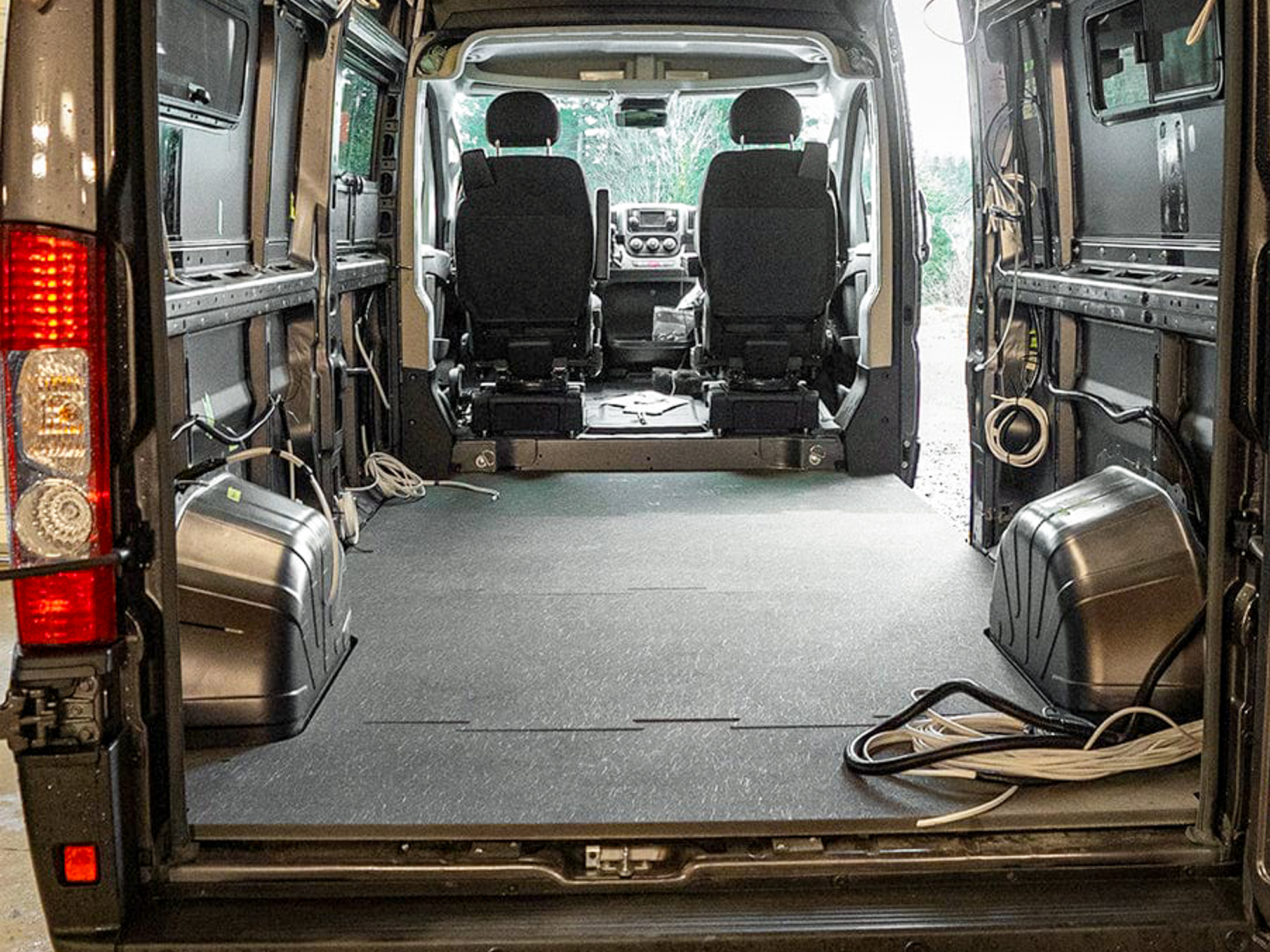 The Rainier Flooring Kit subfloor pieces laid out inside a van interior.