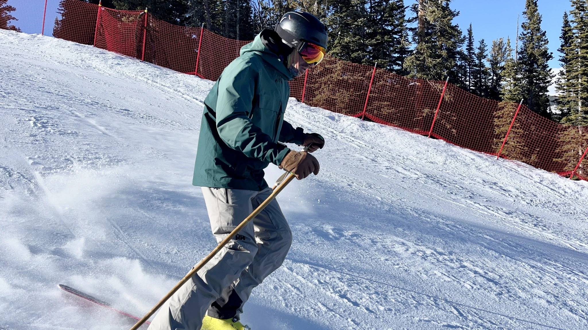 A skier carving on-piste in an REI Co-op First Chair GTX jacket.