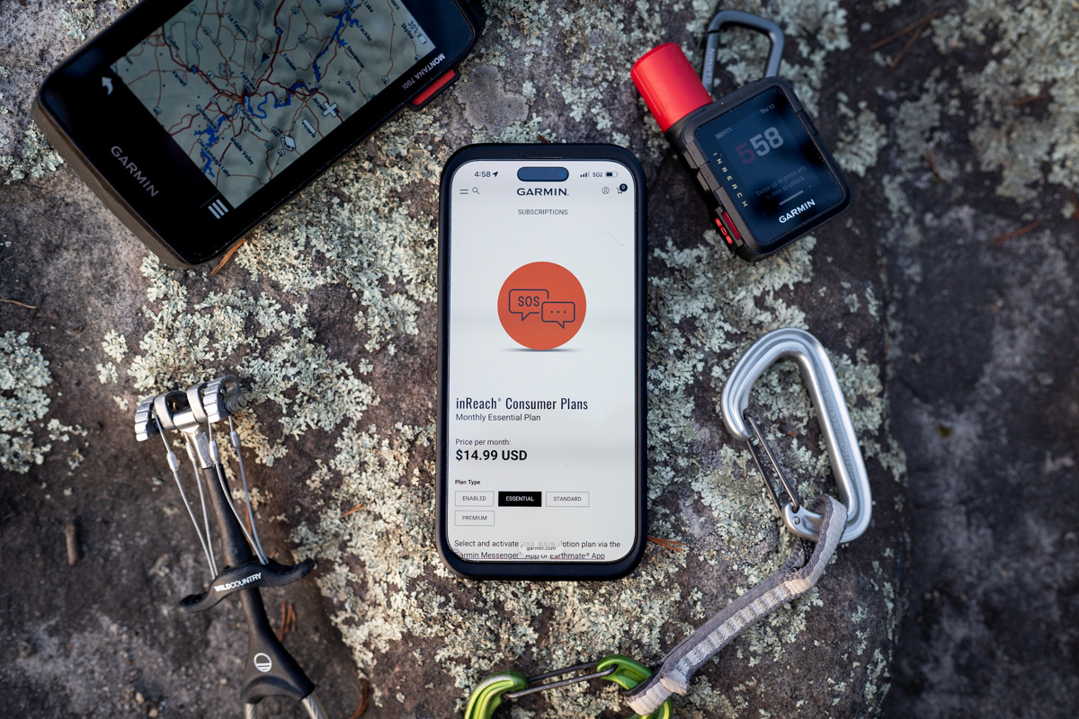 Two Garmin inReach units and a smartphone paired together on a rocky surface.