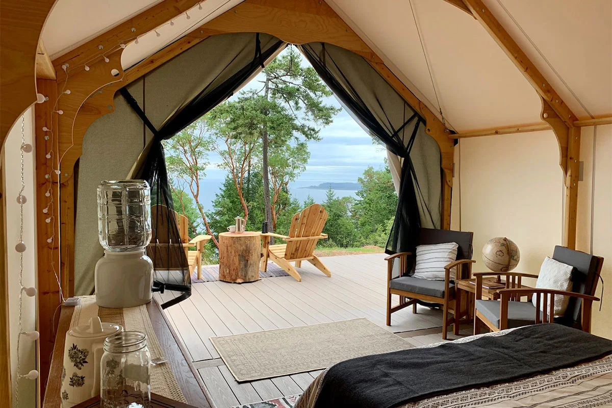 Interior of a spacious luxury glamping tent in Clallam featuring a full bed and stylish furniture.