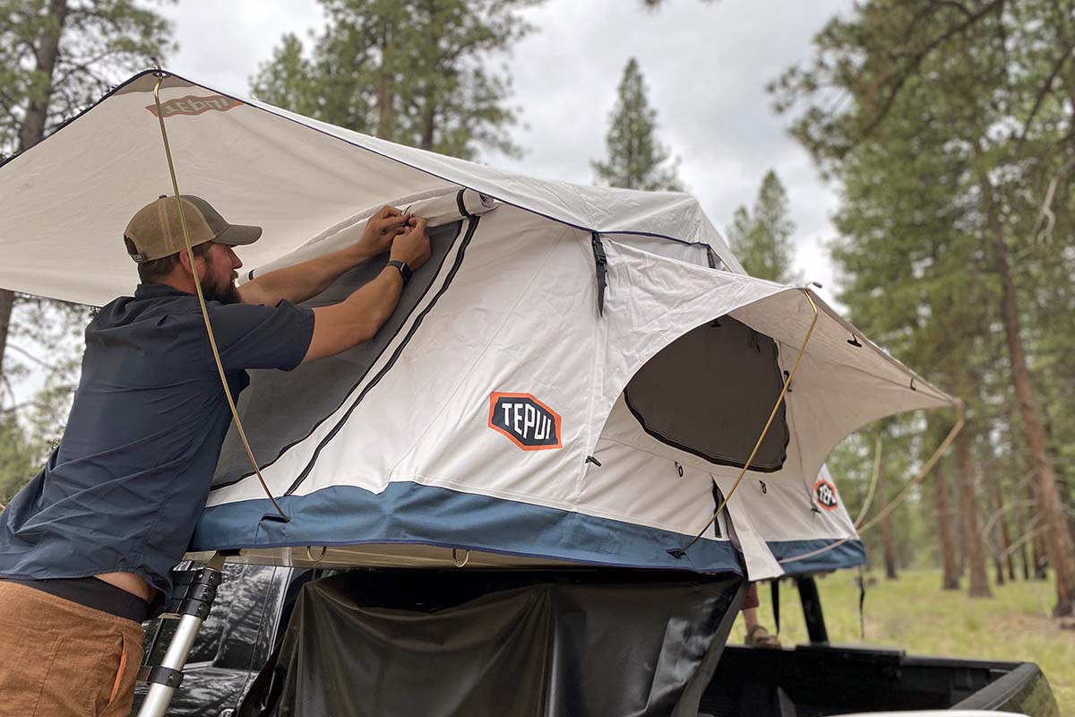 Side view of a Tepui Low Pro softshell rooftop tent with its window shade rolled up.