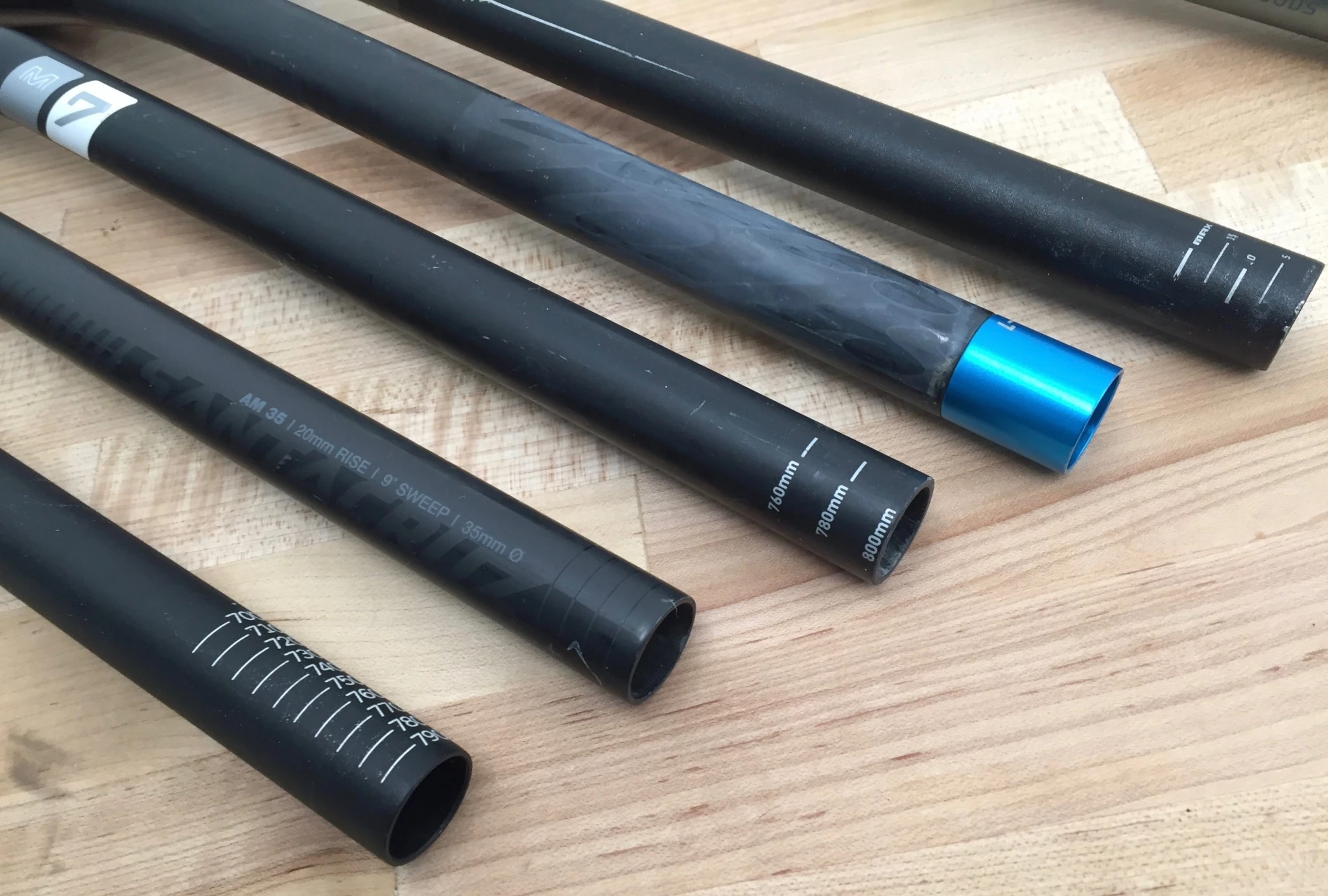 Close-up of the end of a mountain bike handlebar showing printed measurement lines for trimming.