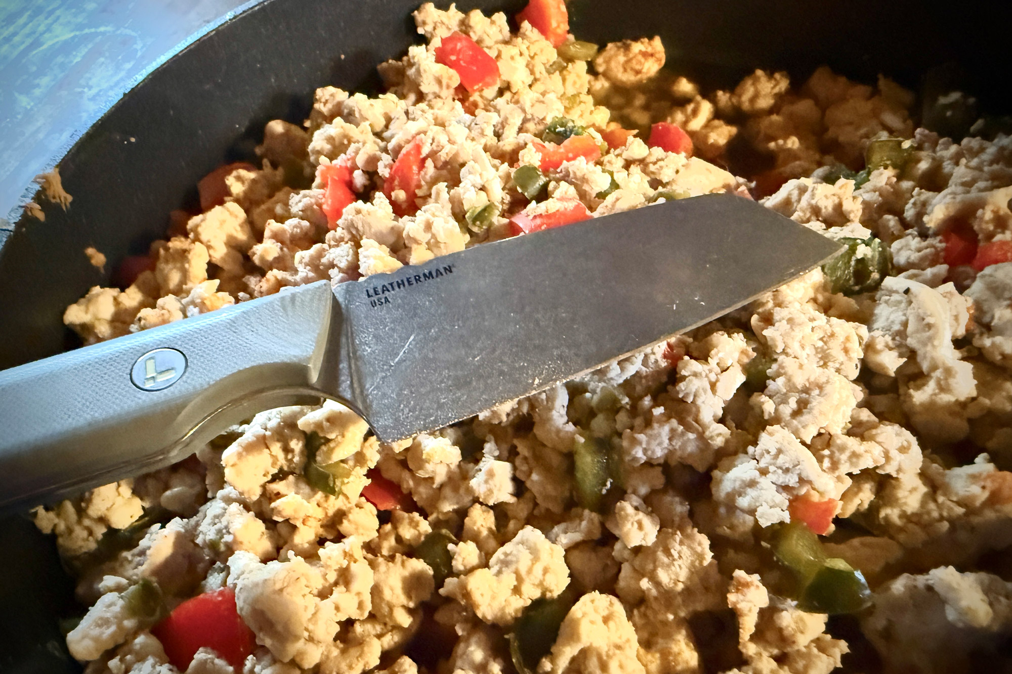 Leatherman Rustle placed over a pan of cooked chicken and vegetables.