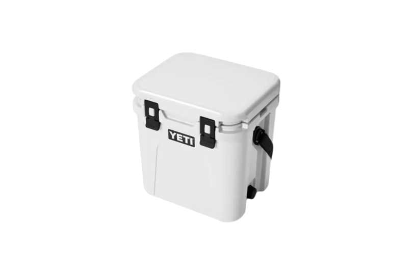 A blue Yeti Roadie 24 cooler standing on grass.