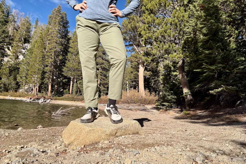 Close-up of the Notace Yama T1 worn with hiking pants near a body of water.