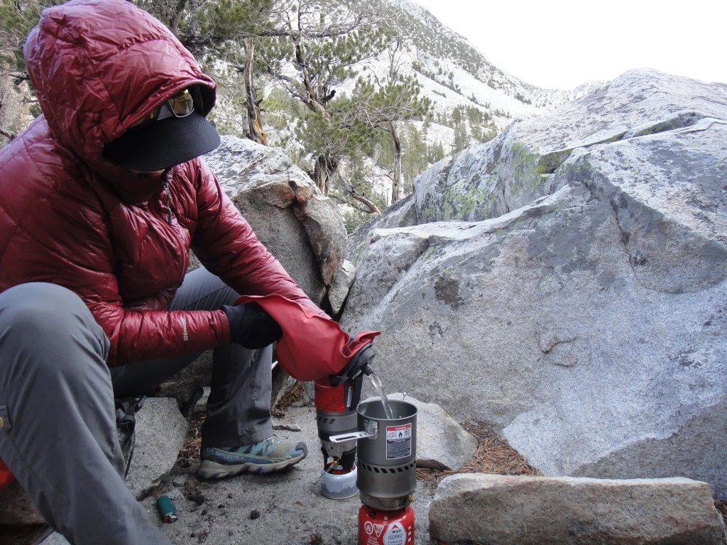 Outdoor gear tester Jessica Haist evaluating MSR WindBurner and Reactor stoves in a cold, windy alpine environment.