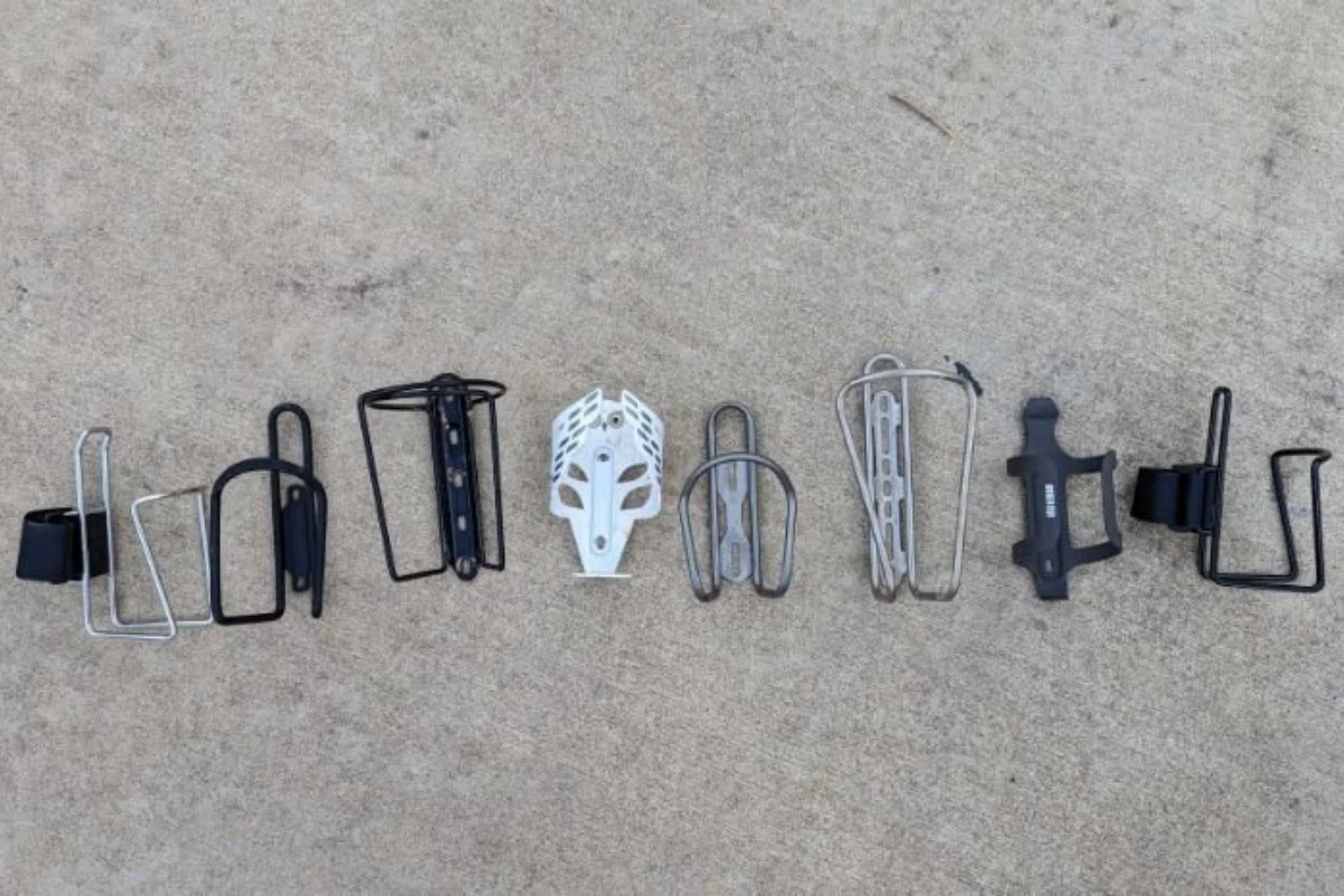 A comprehensive lineup of the 12 water bottle cages tested, ranging from plastic to stainless steel.