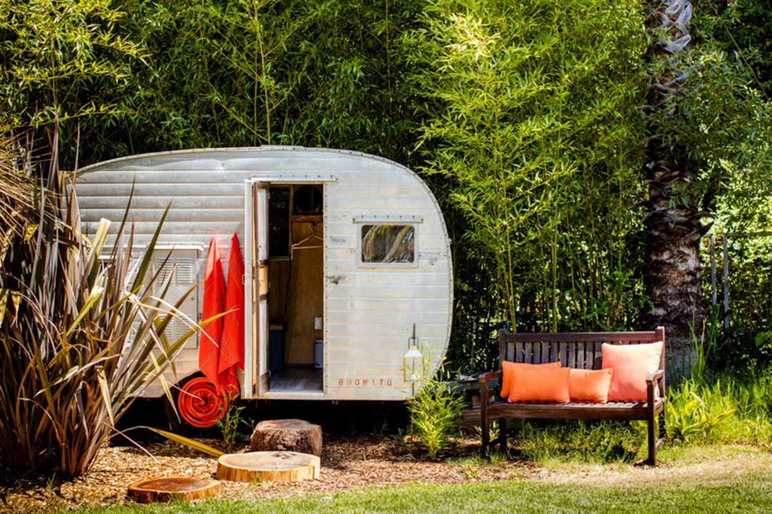 A luxury tent setup at Boon Glamping in Guerneville shaded by mature trees.