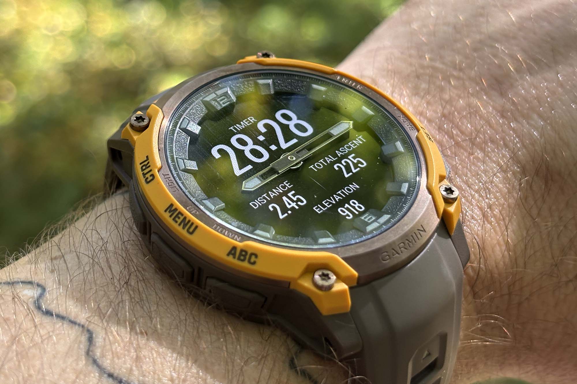 Macro close-up of the Garmin Instinct Crossover bezel and physical watch hand.