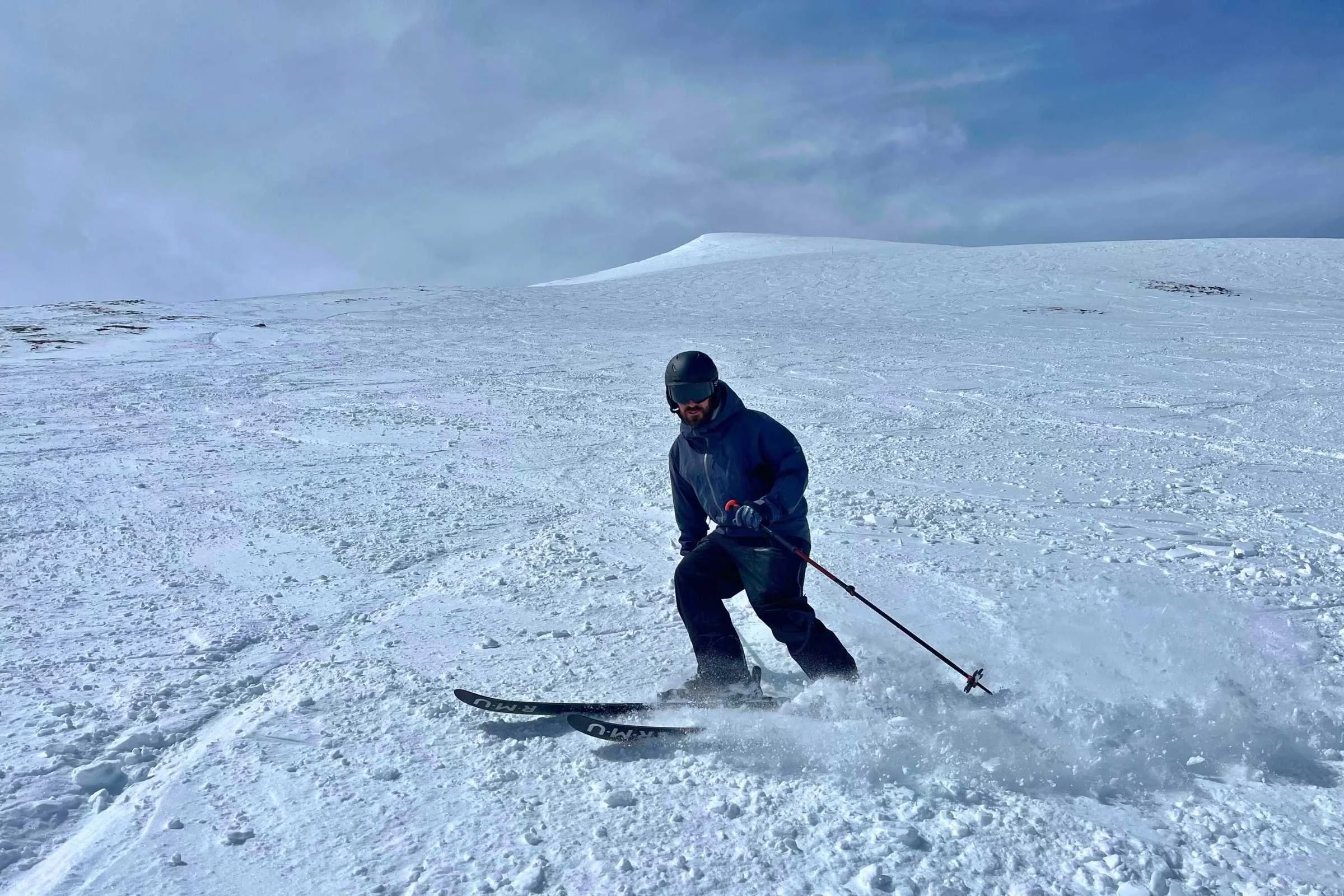A skier testing the fit and stability of a Smith Level helmet in snowy conditions.