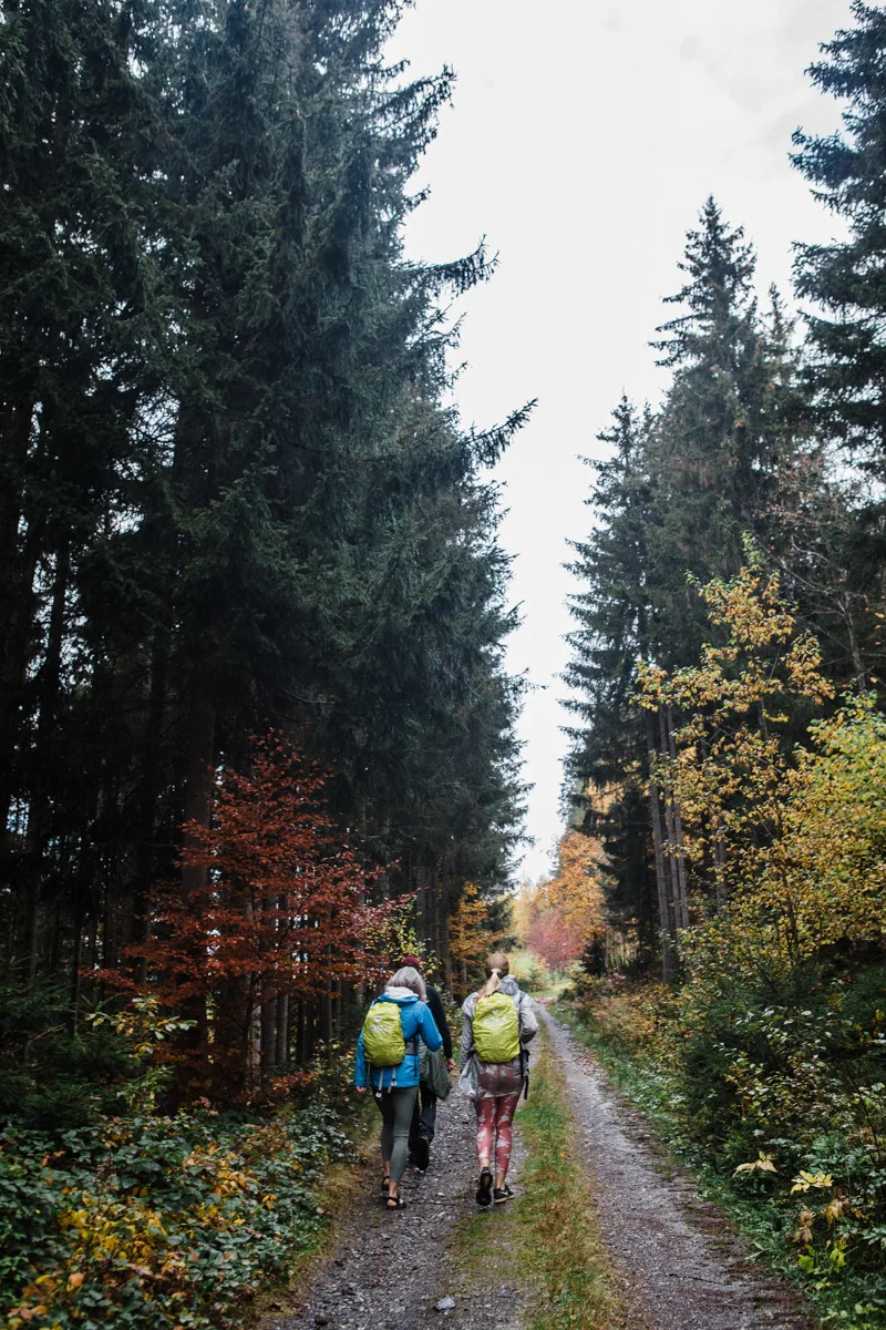 Two hikers navigating a narrow mountain ridge under a clear blue sky in Salzburg.